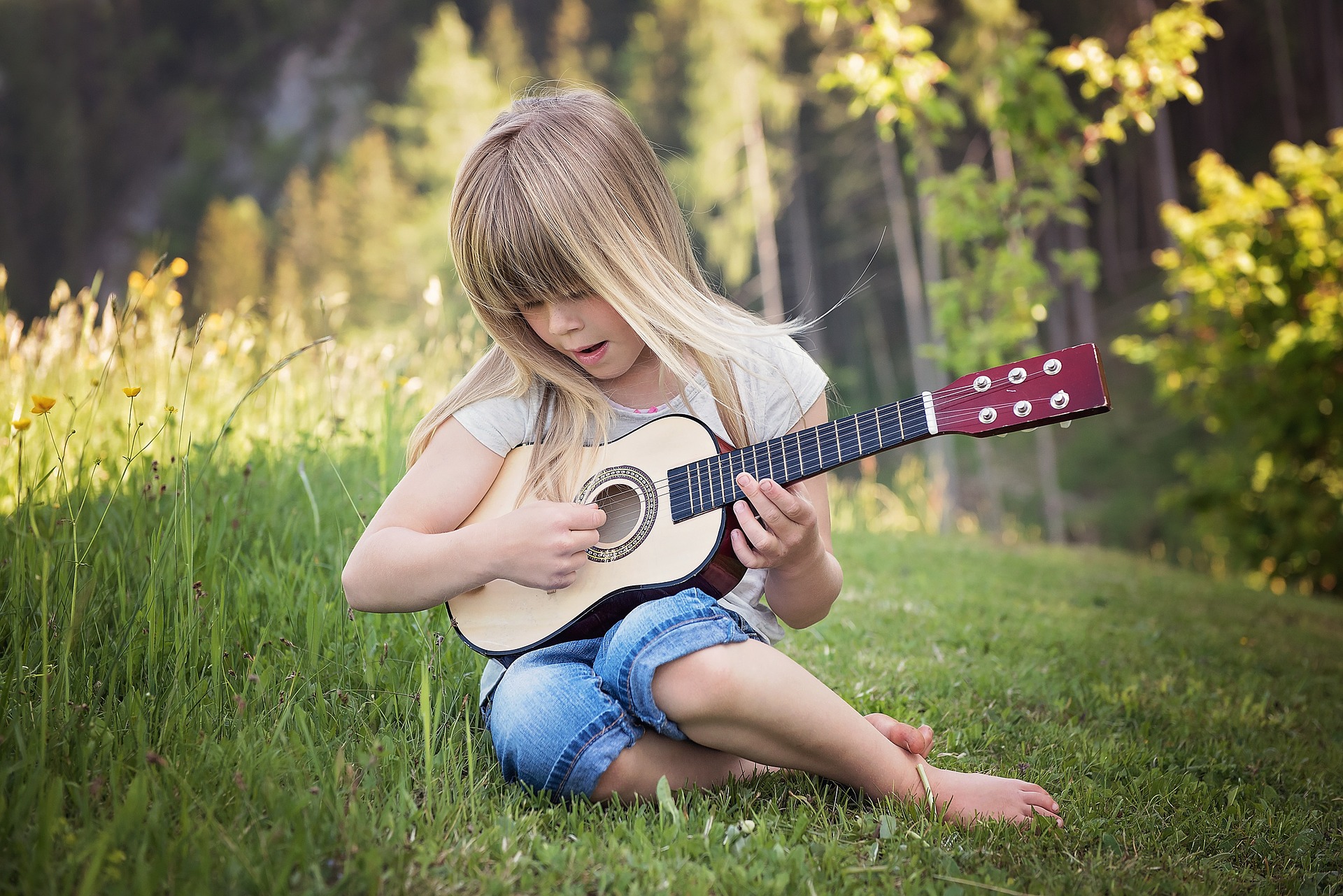 Dziewczynka grająca na zabawkowej gitarze